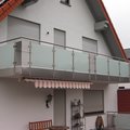 Edelstahlgeländer mit Milchglasscheiben an einem Balkon