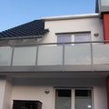 Edelstahlgeländer mit Milchglasscheiben an einem Balkon