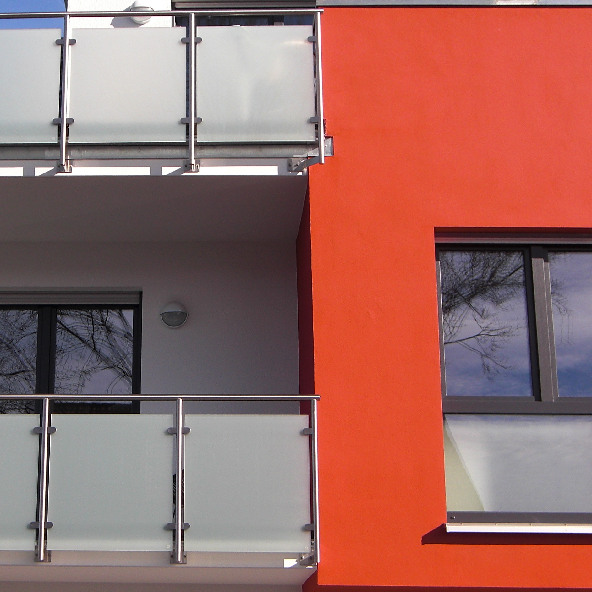 Ein rotes Gebäude mit Balkon und Fenster.