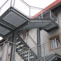 Eine Feuertreppe aus Metall mit Edelstahlhandlauf an der Seite eines Gebäudes.