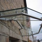 Glasvordach an einer Haustür mit Edelstahlhalterung